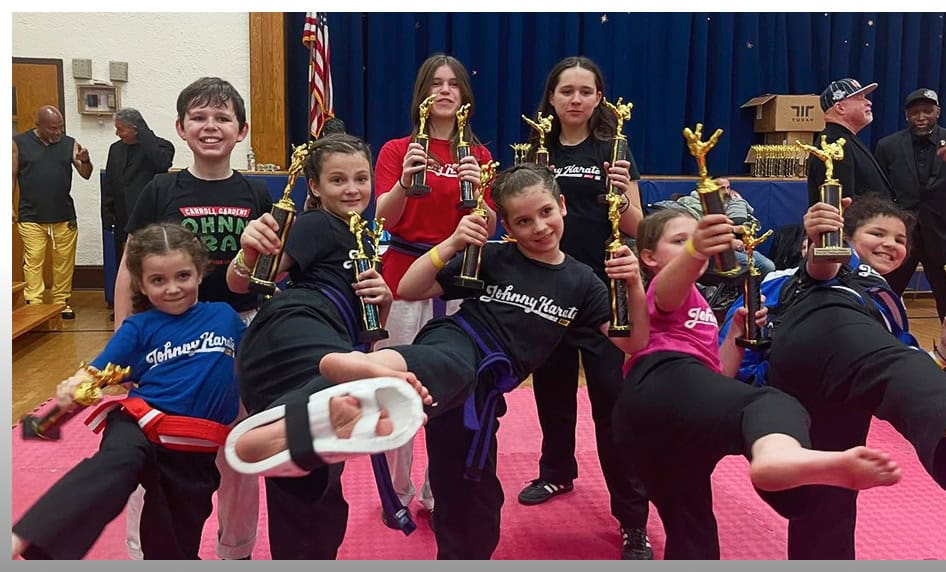 Children practicing martial arts with trophies at Johnny Karate NYC.