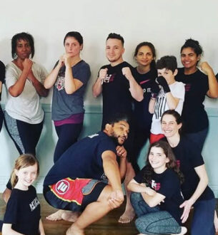 Group of diverse adults and children practicing martial arts in NYC studio.