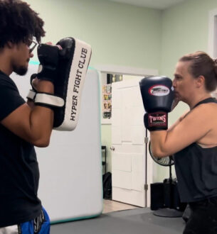 Young man practicing boxing with trainer at Johnny Karate NYC gym.