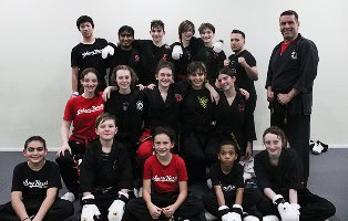 Group of children and instructor in martial arts uniforms at Johnny Karate NYC class.