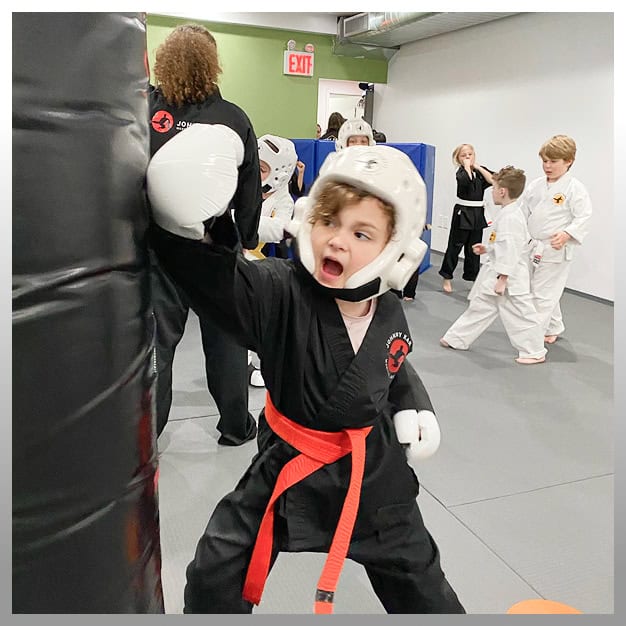 Young boy practicing martial arts with a punch at Johnny Karate NYC.