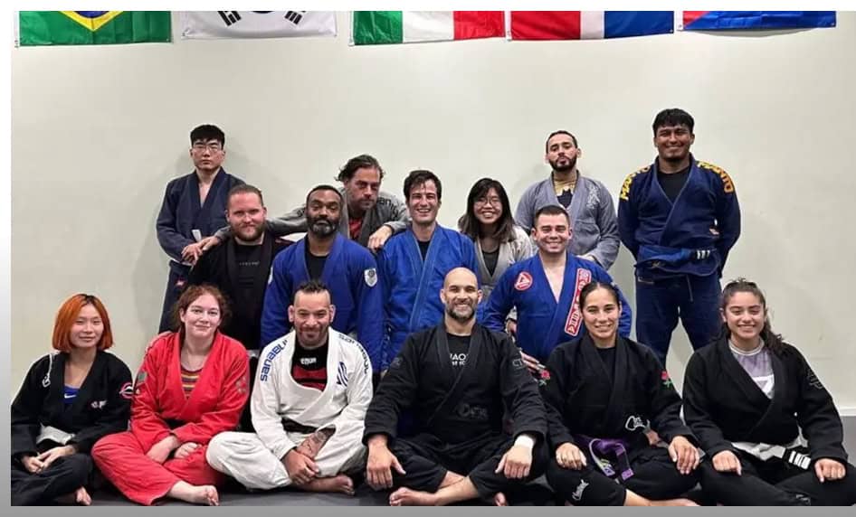 Group photo of JMA Adult BJJ students and instructor in martial arts uniforms.