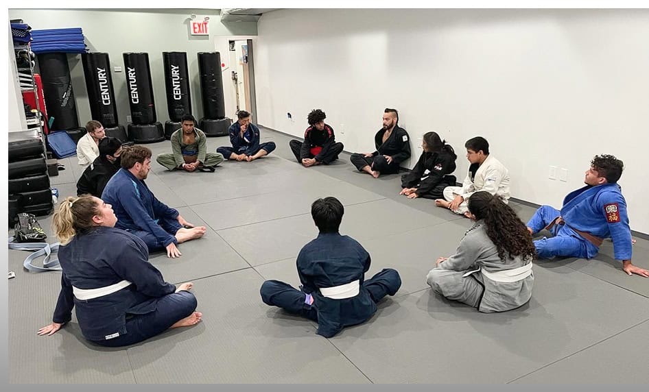 Teen BJJ students sitting in a circle during a class at Johnny Karate NYC.