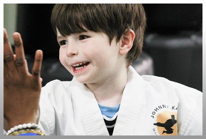Child smiling during martial arts class at Johnny Karate NYC.