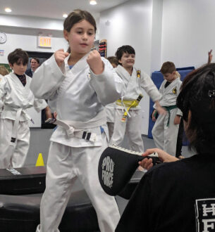 Kids martial arts class practicing punches and kicks at Johnny Karate NYC.