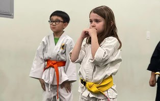 Young children practicing martial arts in a class at Johnny Karate NYC, focusing on discipline and f.