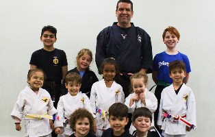 Kids and instructor in karate uniforms during class at Johnny Karate NYC.