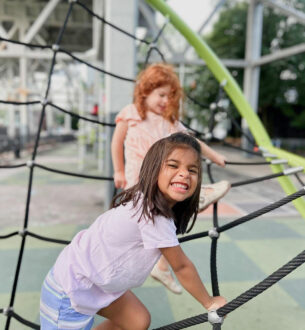 Children enjoying outdoor activities at summer camp playground in NYC.