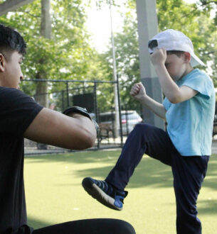 Young boy practicing martial arts at summer camp in NYC, demonstrating discipline and focus.
