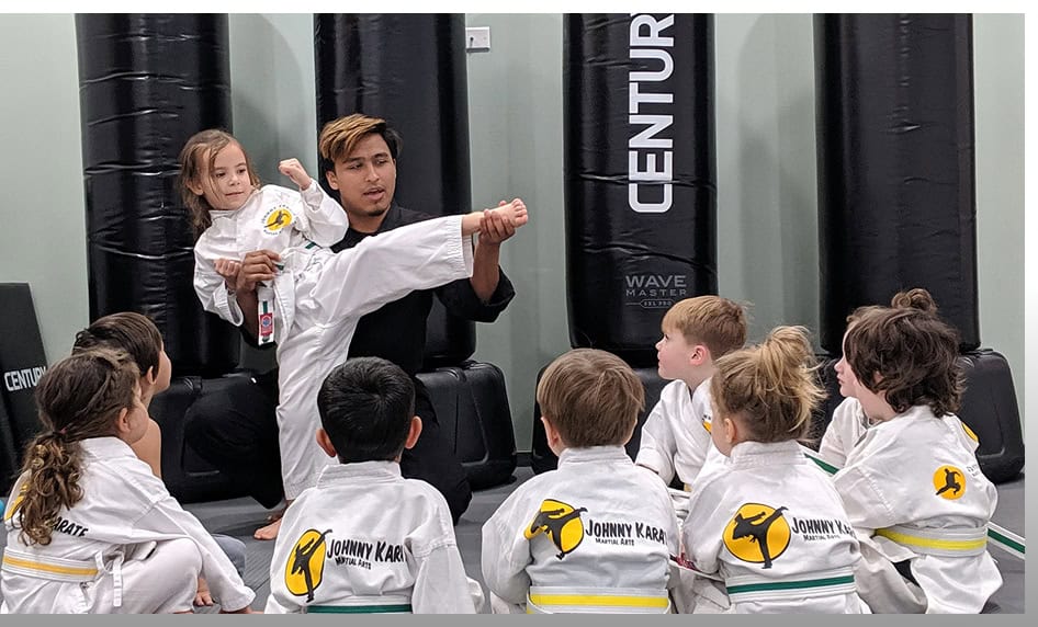 Young students learning martial arts techniques from Johnny Karate NYC instructor.