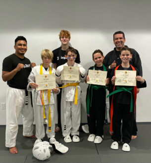 Johnny Karate NYC Teen Martial Arts class with students celebrating their achievements.