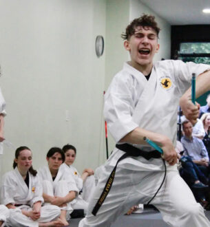 Teen martial artist performing a high kick during karate class in NYC.